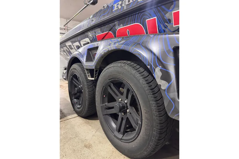 Slide: The Image of 2025 Ranger Z520 boat trailer with black wheels and blue graphic design. - 88