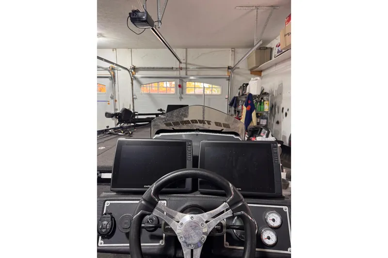 Slide: The Image of 2025 Ranger Z520 boat dashboard with dual Garmin screens in a garage setting. - 91