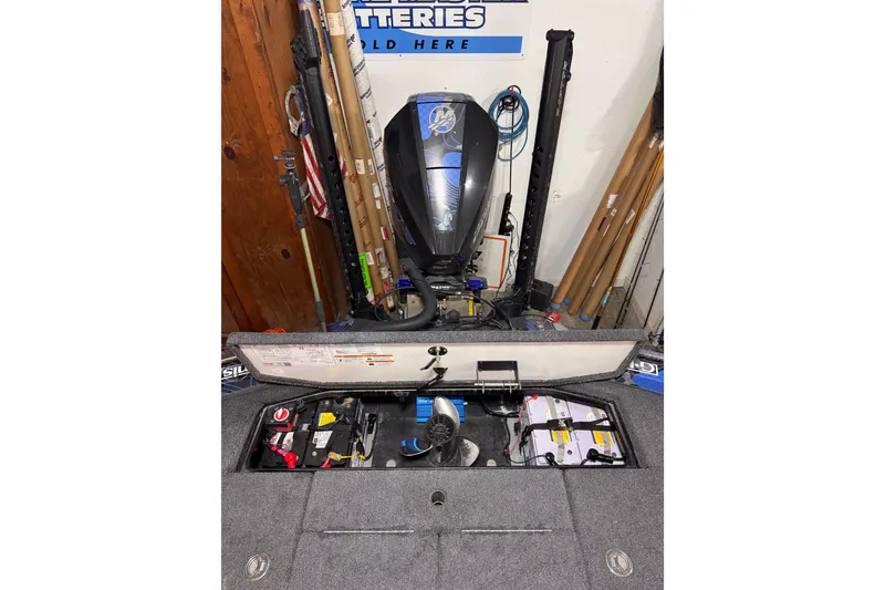 Slide: The Image of 2025 Ranger Z520 boat battery compartment with equipment and tools in a garage setting. - 92