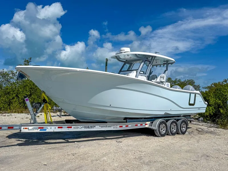 Slide: The Image of 2025 Sea Fox 328 Commander boat on a trailer, parked outdoors under a blue sky. - 0
