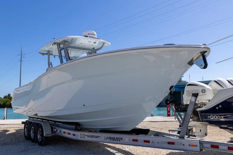 Slide: The Image of 2025 Sea Fox 328 Commander boat on trailer, side view under clear blue sky. - 1