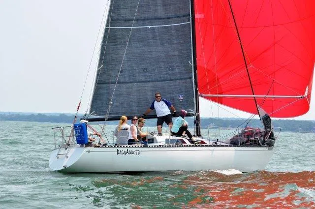 Slide: The Image of Sailboat Abbott 33 (1987) with red and black sails on open water. - 1