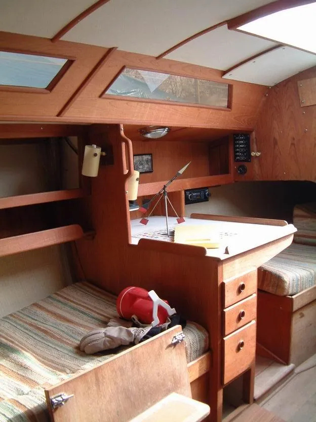 Slide: The Image of Interior of a 1987 Abbott 33 sailboat, featuring wooden cabinetry and cozy seating. - 10