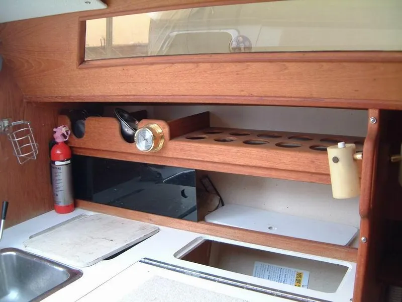 Slide: The Image of Interior of 1987 Abbott 33 sailboat with wooden cabinetry and kitchen essentials. - 12