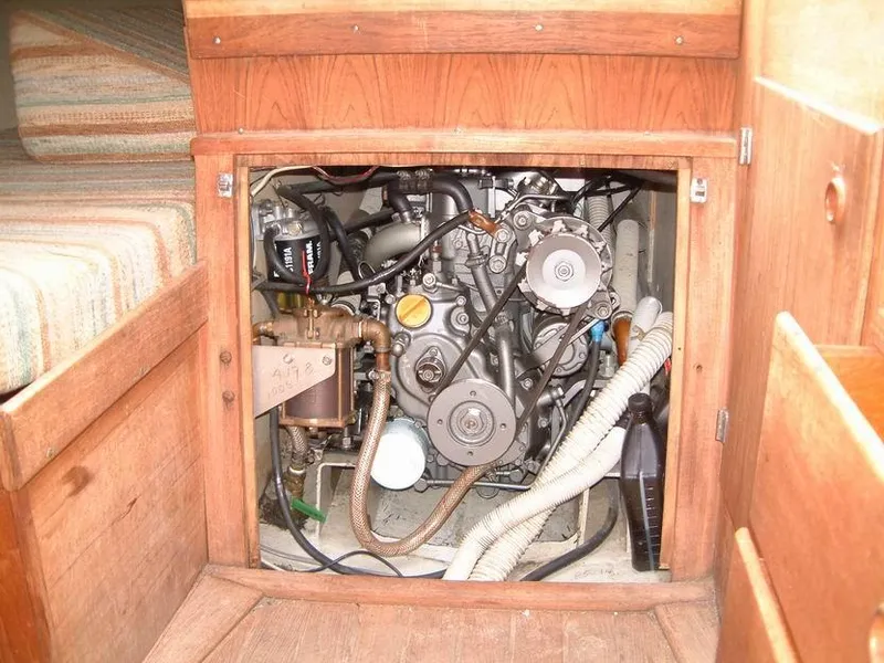 Slide: The Image of Engine compartment of a 1987 Abbott 33 sailboat, showcasing mechanical components and wooden cabinetry. - 14