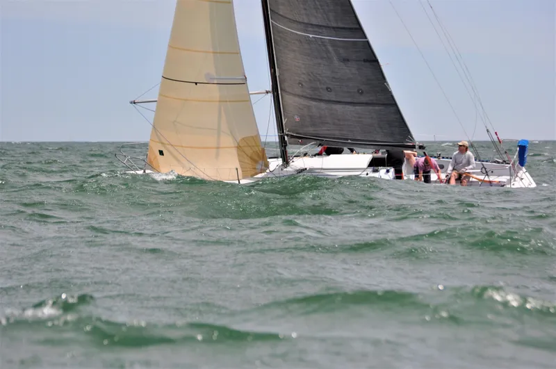 Slide: The Image of Sailboat Abbott 33 (1987) navigating choppy waters with beige and black sails. - 3