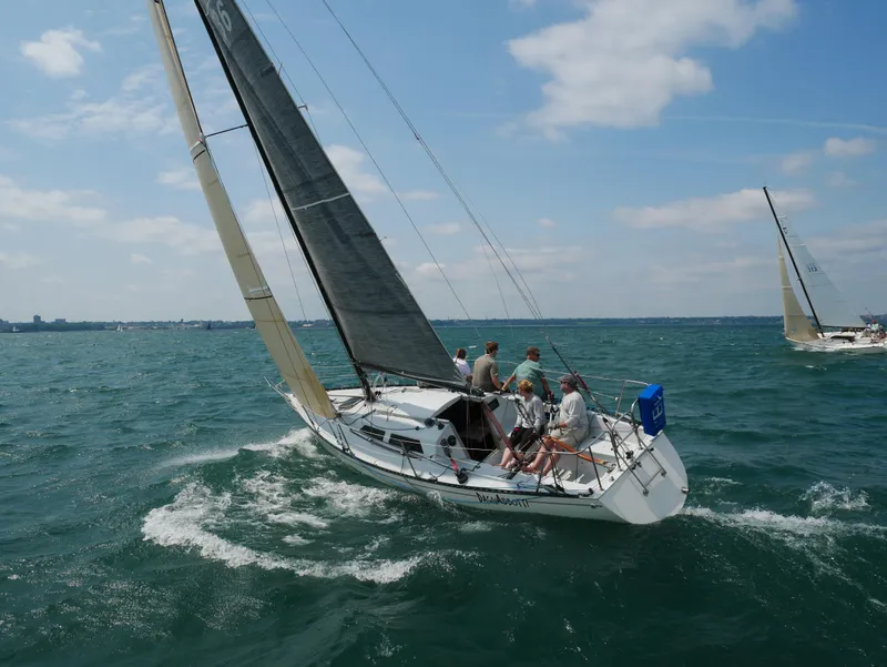 Slide: The Image of Sailboat Abbott 33 (1987) navigating on open water with crew under clear skies. - 4