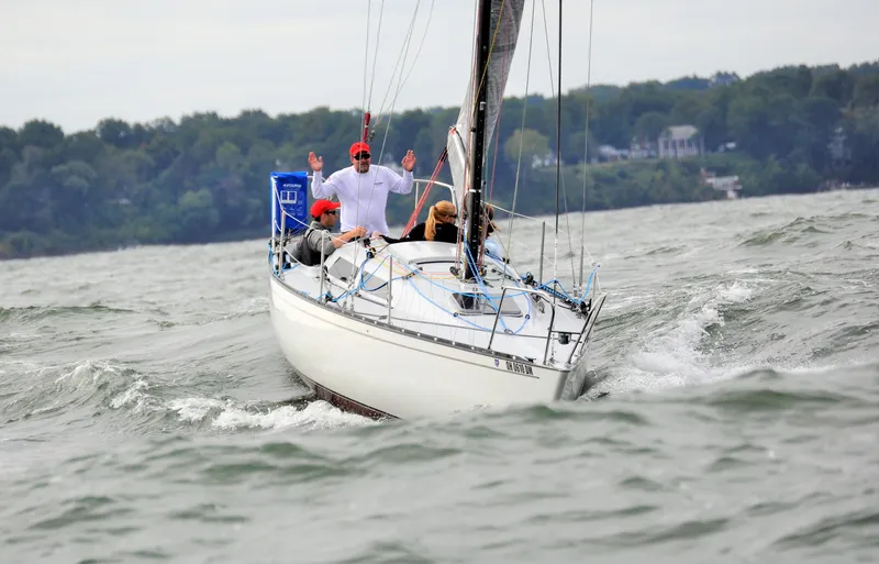 Slide: The Image of Sailboat Abbott 33 (1987) navigating choppy waters with crew, forested shoreline in background. - 5