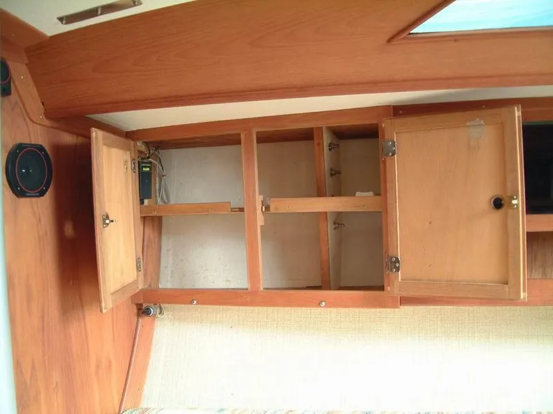 Slide: The Image of Wooden interior cabinets in a 1987 Abbott 33 sailboat, showcasing open storage compartments. - 9