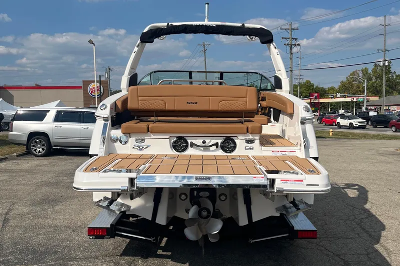 Slide: The Image of 2025 Chaparral 267 SSX boat with tan seating, displayed outdoors in a parking lot. - 22
