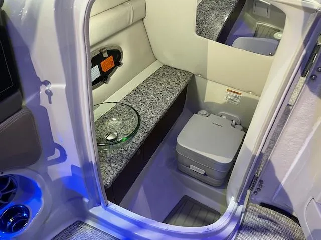 Slide: The Image of 2025 Crownline Eclipse E285 boat interior with compact bathroom and modern amenities. - 6