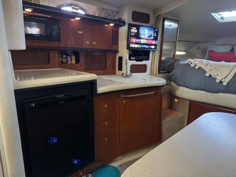 Slide: The Image of Interior of 2000 Sea Ray 340 Sundancer with kitchenette and cozy sleeping area. - 12