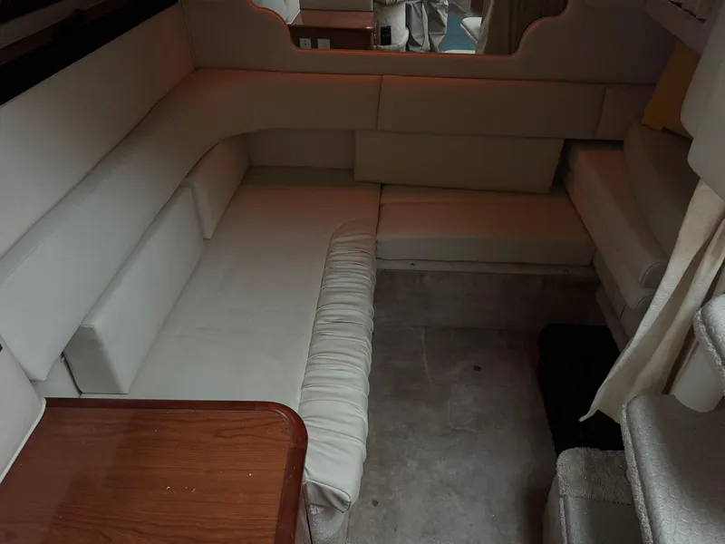 Slide: The Image of Interior of 2000 Sea Ray 340 Sundancer with beige seating and wooden table. - 13