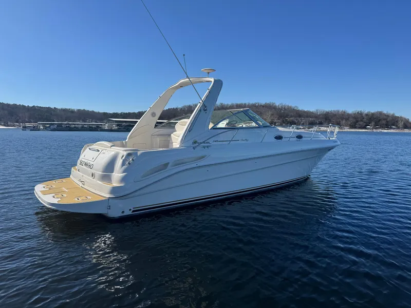 Slide: The Image of 2000 Sea Ray 340 Sundancer boat on calm water under clear blue sky. - 2