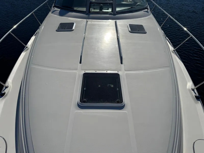 Slide: The Image of 2000 Sea Ray 340 Sundancer boat deck with hatches and railing, on calm water. - 7