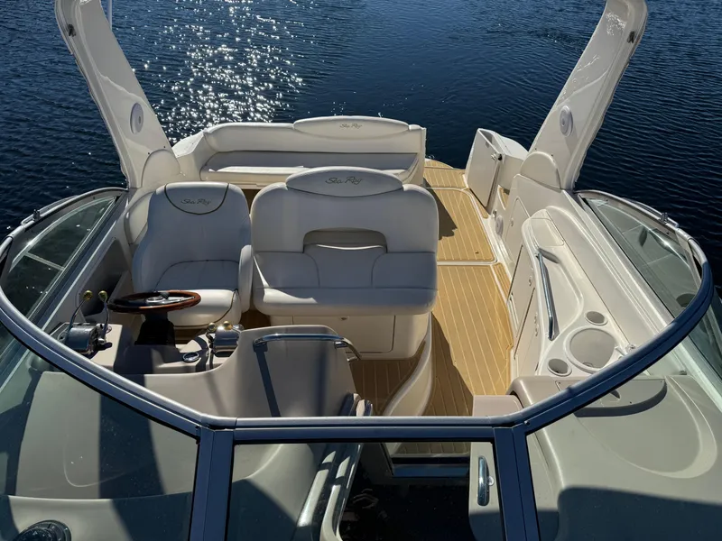 Slide: The Image of 2000 Sea Ray 340 Sundancer boat interior with seating and steering wheel on calm water. - 8