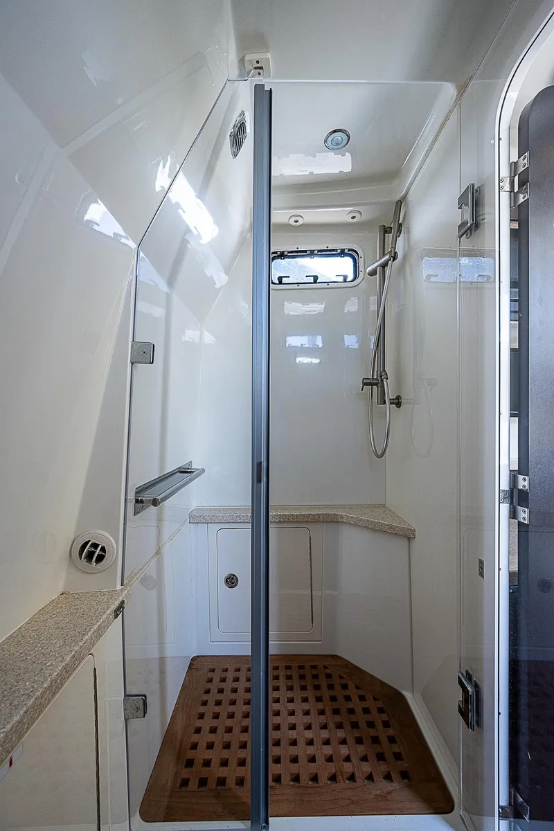 Slide: The Image of Luxurious shower area in 2016 HCB 53 Sueños boat with modern fixtures and wooden floor mat. - 16