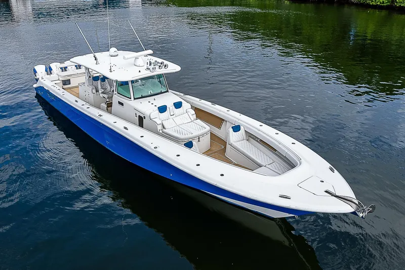 Slide: The Image of Luxury 2016 HCB 53 Sueños boat with sleek blue and white design on calm water. - 6