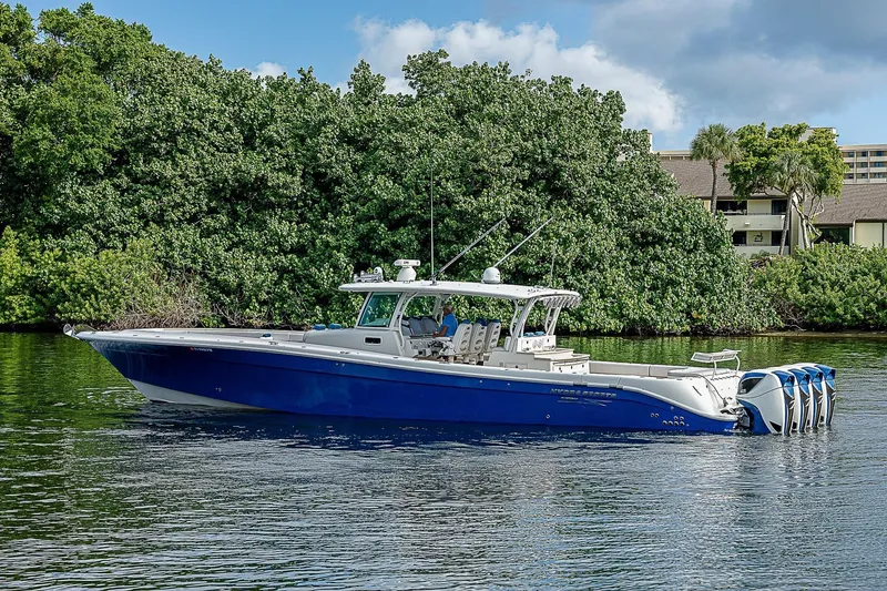 Slide: The Image of 2016 HCB 53 Sueños boat with blue hull cruising on a calm waterway. - 4