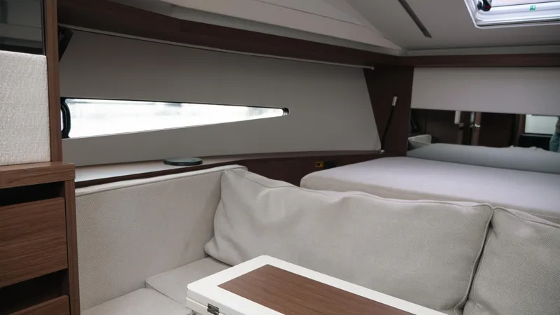 Slide: The Image of Interior of 2019 Jeanneau Leader 33 yacht, featuring a cozy seating area and bed. - 10