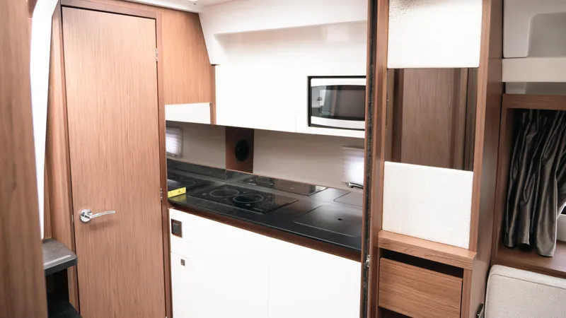 Slide: The Image of 2019 Jeanneau Leader 33 yacht interior kitchen with modern appliances and wood finish. - 15