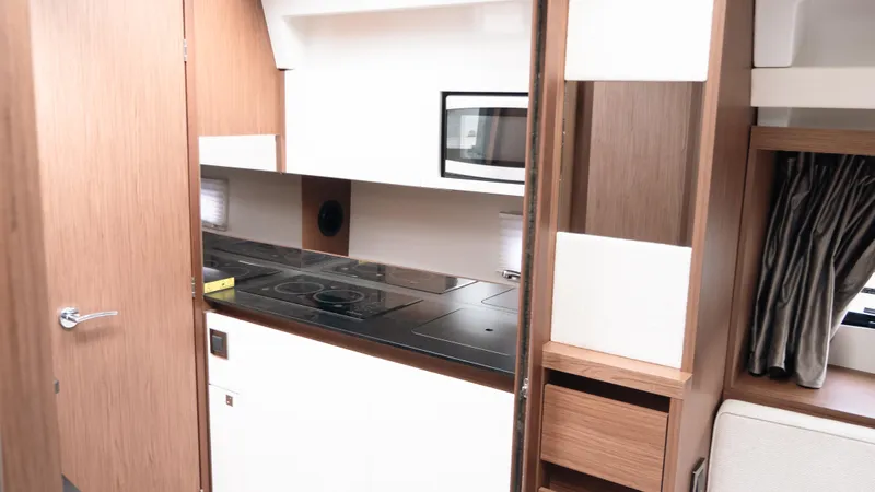 Slide: The Image of 2019 Jeanneau Leader 33 yacht interior kitchen with modern appliances and wood finish. - 16