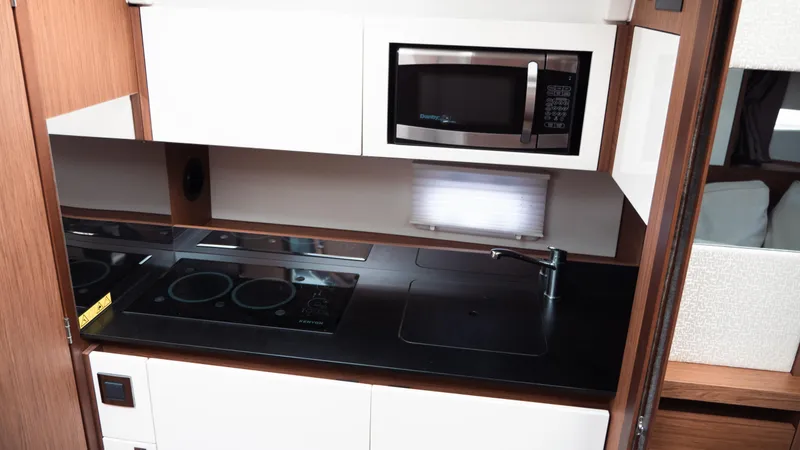 Slide: The Image of 2019 Jeanneau Leader 33 yacht kitchen with stove, microwave, and sink. - 17