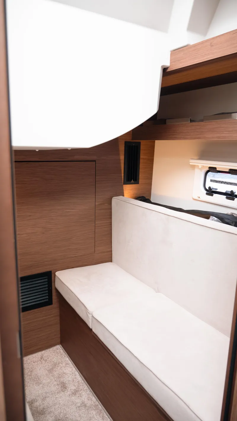 Slide: The Image of 2019 Jeanneau Leader 33 interior cabin with white seating and wooden accents. - 21