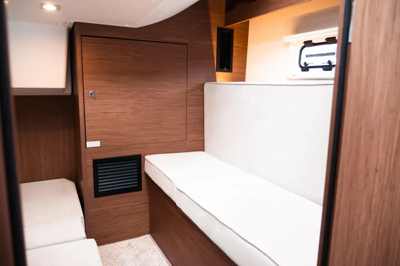 Slide: The Image of Interior cabin of 2019 Jeanneau Leader 33 yacht with wood paneling and white seating. - 23