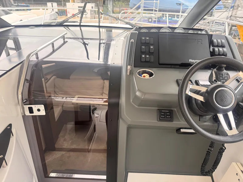 Slide: The Image of 2019 Jeanneau Leader 33 cockpit with steering wheel and navigation controls. - 24