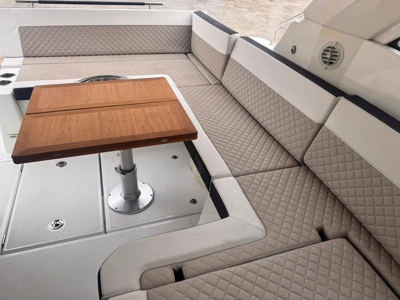 Slide: The Image of 2019 Jeanneau Leader 33 boat interior with quilted seating and wooden table. - 26