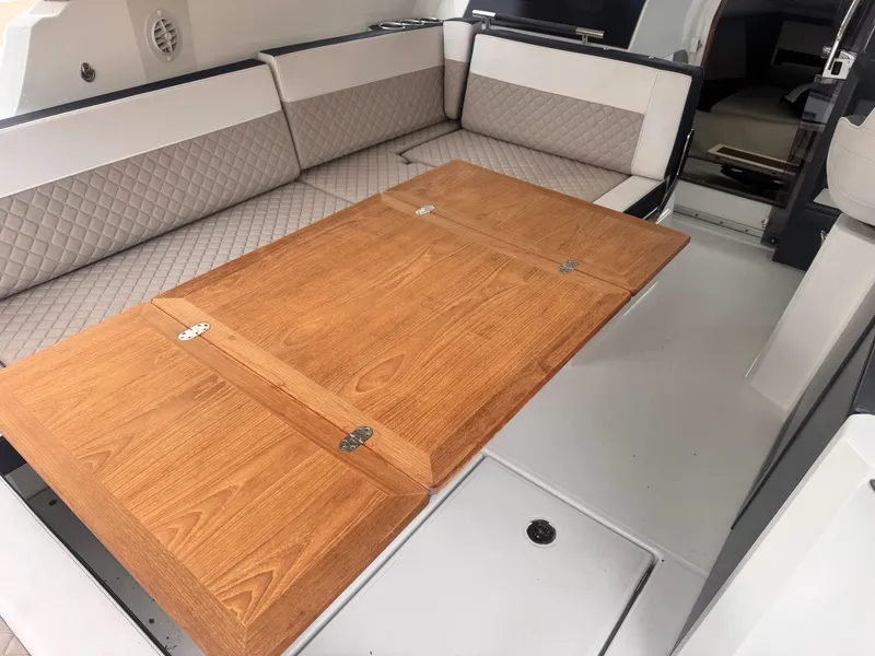 Slide: The Image of Interior seating and wooden table on a 2019 Jeanneau Leader 33 boat. - 27