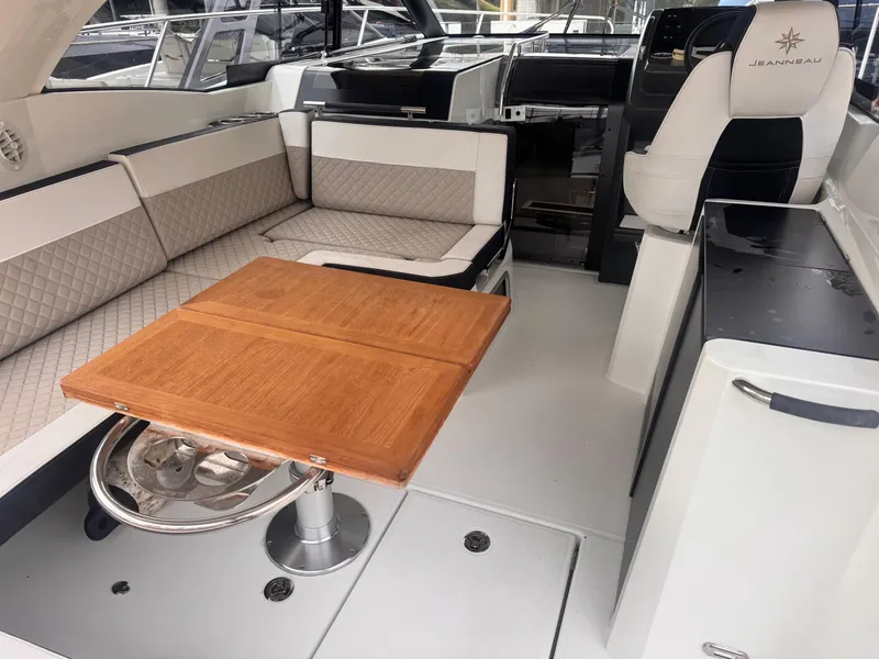 Slide: The Image of 2019 Jeanneau Leader 33 interior with seating and wooden table. - 4
