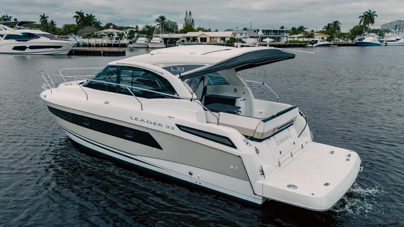 Slide: The Image of 2019 Jeanneau Leader 33 yacht cruising on a calm waterway, showcasing sleek design and luxury features. - 6