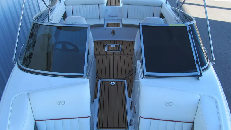 Slide: The Image of 2006 Cobalt 250 boat interior with white seating and wood flooring. - 12