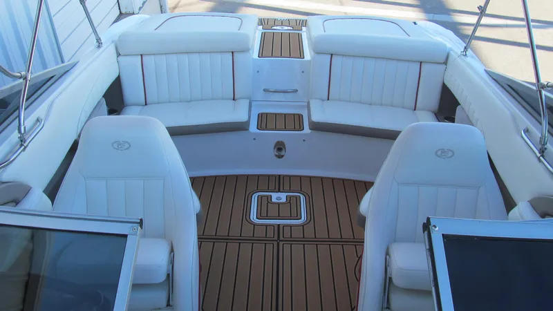 Slide: The Image of Interior of a 2006 Cobalt 250 boat with white seating and wood flooring. - 13