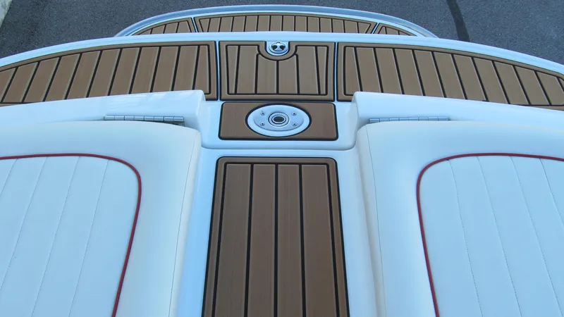 Slide: The Image of 2006 Cobalt 250 boat deck with teak flooring and white cushioned seating. - 16