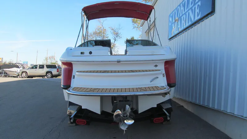 Slide: The Image of 2006 Cobalt 250 boat with red canopy, parked near marine store. - 4