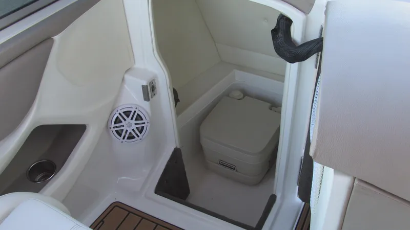 Slide: The Image of 2006 Cobalt 250 boat interior with compact marine toilet and speaker. - 9