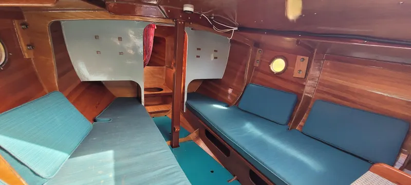 Slide: The Image of Interior of 2009 Golant Gaffer Cutter Rig with wooden finish and blue seating. - 11