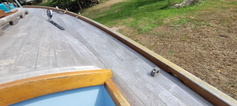 Slide: The Image of Wooden deck of a 2009 Golant Gaffer Cutter Rig sailboat, with grassy background. - 37