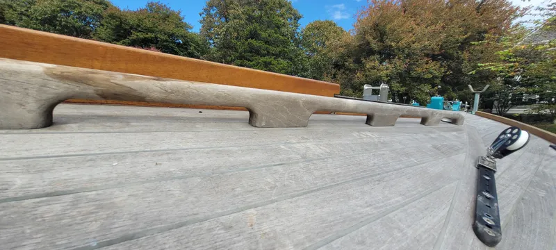 Slide: The Image of Wooden deck of 2009 Golant Gaffer Cutter Rig sailboat with trees in background. - 38