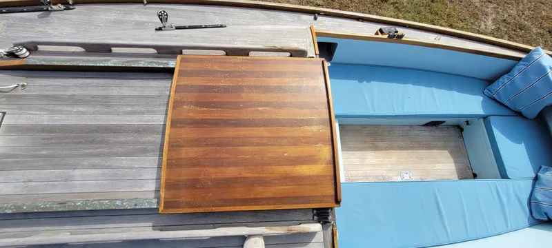 Slide: The Image of Golant Gaffer Cutter Rig 2009 boat deck with wooden table and blue seating. - 46