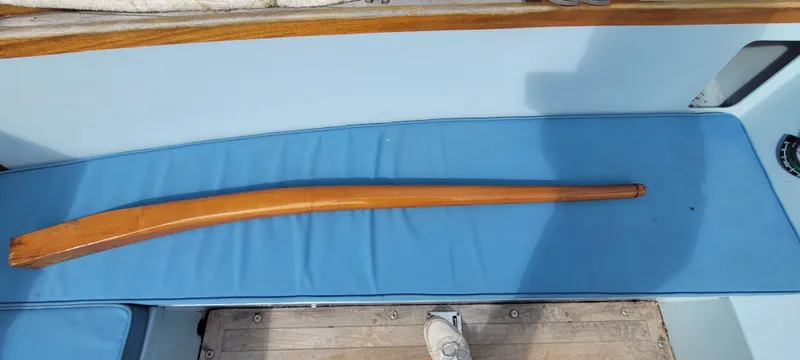 Slide: The Image of Wooden tiller on Golant Gaffer Cutter Rig, 2009, resting on blue boat seat. - 49