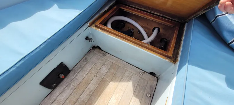 Slide: The Image of Open storage compartment on 2009 Golant Gaffer Cutter Rig boat with visible hose. - 7