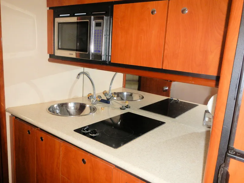 Slide: The Image of 2006 Fountain 48 Express Cruiser kitchen with microwave, dual sinks, and stovetop. - 8