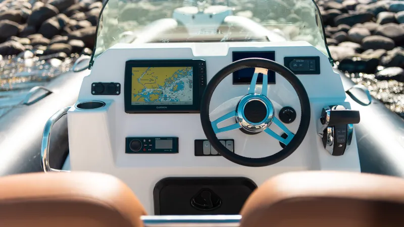 Slide: The Image of 2025 Zodiac Medline 7.5 boat dashboard with navigation screen and steering wheel. - 3