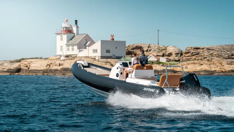 Slide: The Image of Zodiac Medline 7.5 boat cruising near a coastal lighthouse, 2025 model. - 4