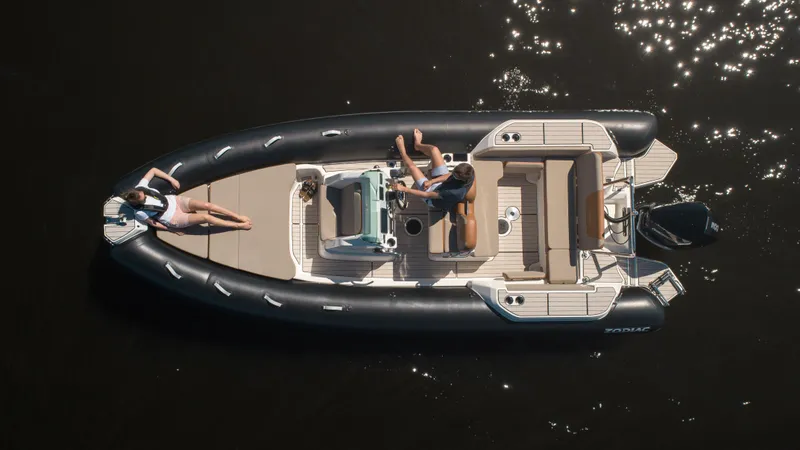 Slide: The Image of 2025 Zodiac Medline 7.5 boat on water, aerial view, with two people relaxing onboard. - 2