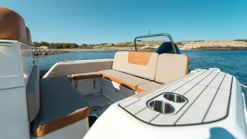 Slide: The Image of 2025 Zodiac Medline 7.5 boat interior with seating and cup holders, on a sunny day by the water. - 5